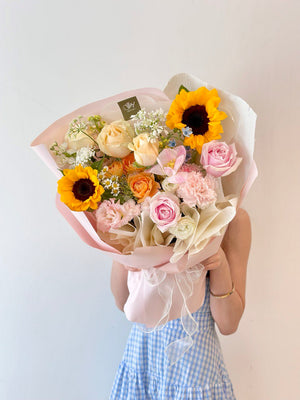 A girl in a blue dress holds a sunflower bouquet, joyfully celebrating her graduation day in Kuala Lumpur.