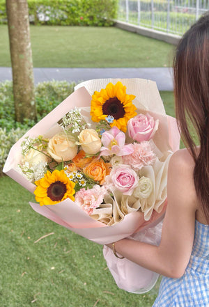 A girl wearing a blue dress holds a vibrant sunflower bouquet, marking her graduation day in Kuala Lumpur.