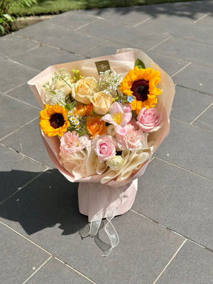 A vibrant sunflower bouquet is placing on grey tiles with a glaze of sunflower in Kuala Lumpur.