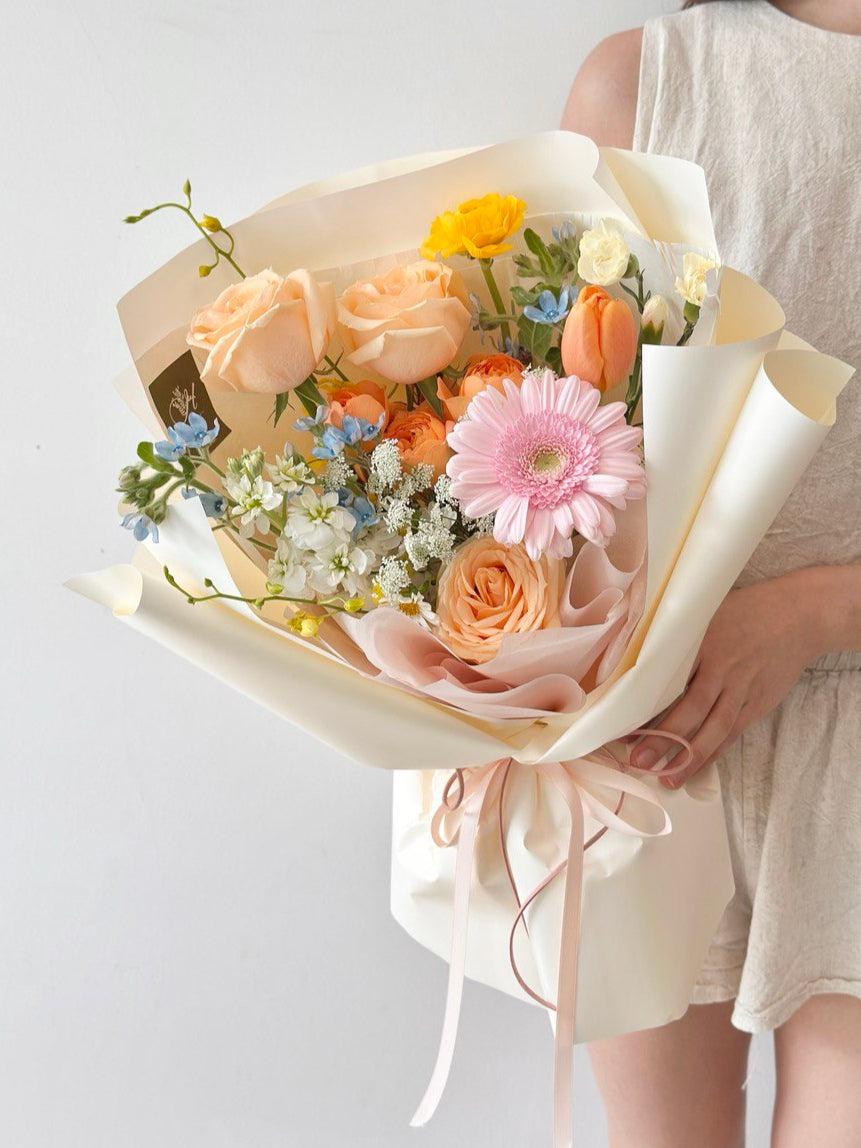 Person holding a bouquet of flowers against a plain background