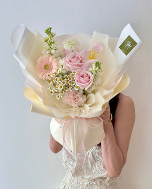 A woman holds a vibrant bouquet of tulips and gerbera flowers during a birthday photoshoot, smiling joyfully.