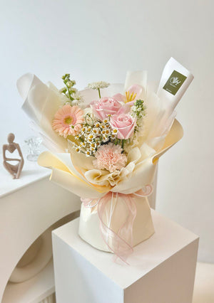 A tulip mixed with gerbera flower bouquet is placing on top of a table for a photoshoot for birthday.