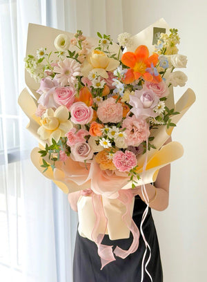 L size mixed flower bouquet with orange tulips, pink pastel gerbera, pink roses and lilac roses for birthday celebration.