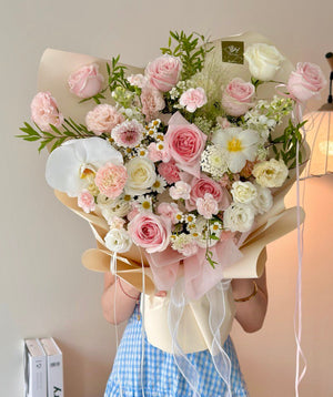 Bouquet of pink and white flowers held by a person in a checkered dress.