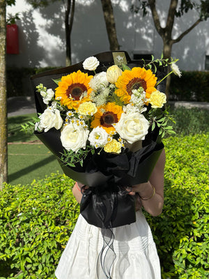 Bright sunflower and rose bouquet designed as a cheerful graduation gift.