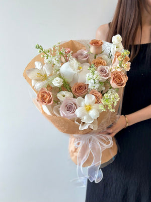 A girl in a black dress showcases a large bouquet of cappuccino roses for her birthday event in Kuala Lumpur.