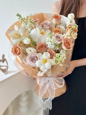 A girl in a black dress showcases a large bouquet of cappuccino roses for her birthday event in Kuala Lumpur.