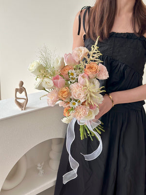 Person holding a bouquet of ROM flowers in a minimalistic setting.