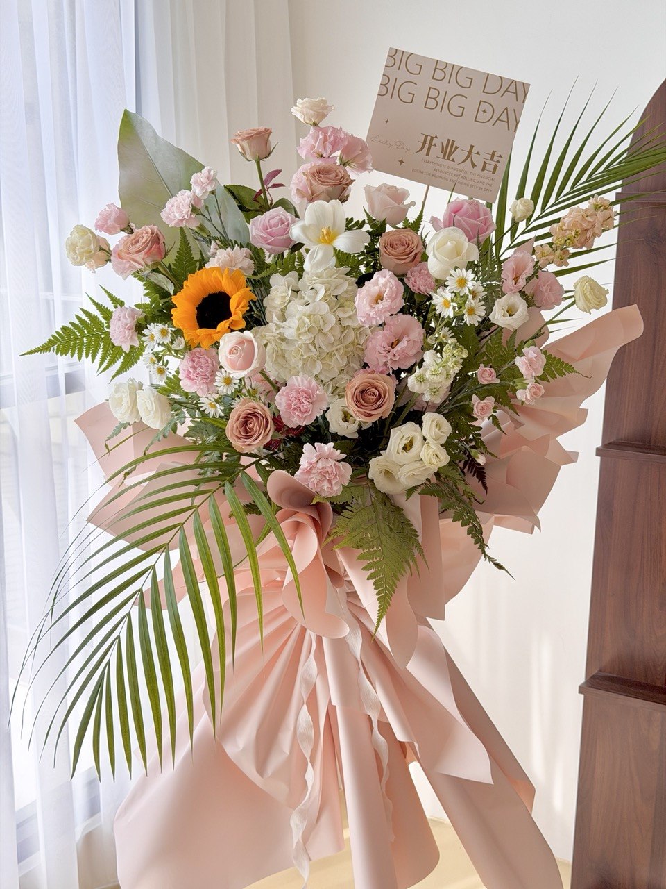 Luxury grand opening flower stand featuring sunflower, white hydrangea, pink roses and elegant tropical foliage. Large congratulatory flower stand with same day delivery in KL, Petaling Jaya, Shah Alam and Selangor by Hug and Heart Florist.