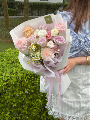 A girl wearing blue top holding a bouquet of lilac rose, pink rose and nude carnation, same day delivery flower at Sunway Square