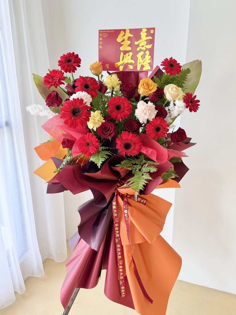Luxury grand opening flower stand with red gerbera, mixed roses, and festive wrapping, same-day grand opening flower stand delivery Kuala Lumpur Selangor.