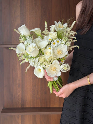 A girl is holding a ROM bridal bouquet with calla lily and white rose for her wedding in Kuala Lumpur.