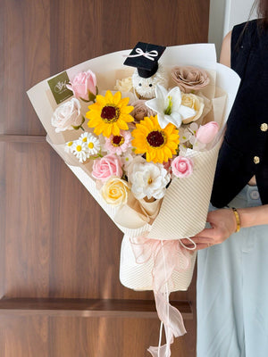A girl is holding a bouquet of graduation soap flower with ping pong graduation hat for her graduation at Sunway University Subang Jaya.