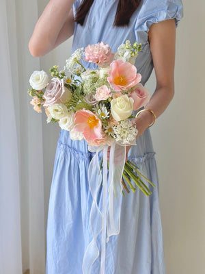 A girl is holding a bouquet of ROM flower consist of tulip, menta rose, white eustoma and other fillers - same day delivery wedding flower at Kuala Lumpur and Selangor.