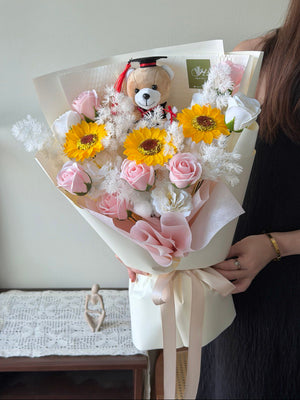 A bouquet of soap flower graduation bouquet is holding by a girl for her graduation event.