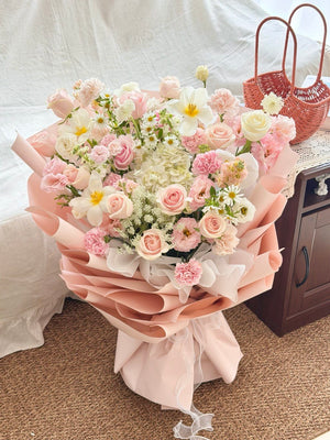Bouquet of pink and white flowers on a table with a textured white background prepared by hug and heart florist subang jaya.