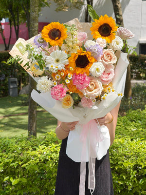 A sunflower graduation bouquet with menta rose, pink rose, gerbera, and dye red carnation perfect for graduation flower.