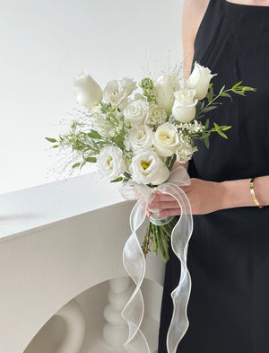 Minimalist floral arrangement in soft white tones, held by someone in a black outfit—perfect for weddings or ROM