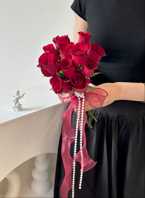Eleven vibrant red roses arranged into a classic bridal bouquet, accented with sheer ribbon and delicate pearl strings—ideal for a ROM or vow ceremony.