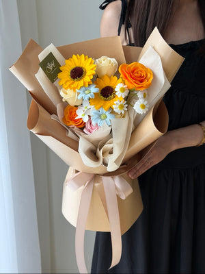 A girl is holding a bouquet of soap flower with soap flower sunflower for her graduation at University.