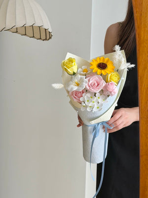 A girl wearing a black dress is holding a small bouquet of soap flower, perfect for graduation at University at Kuala Lumpur.