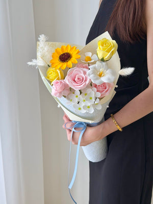 A girl wearing a black dress is holding a small bouquet of soap flower, perfect for graduation at University at Subang Jaya.