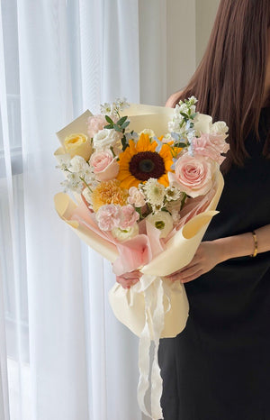 Elegant sunflower flower bouquet featuring blush pink roses, white eustoma, and premium wrapping for graduation bouquet.