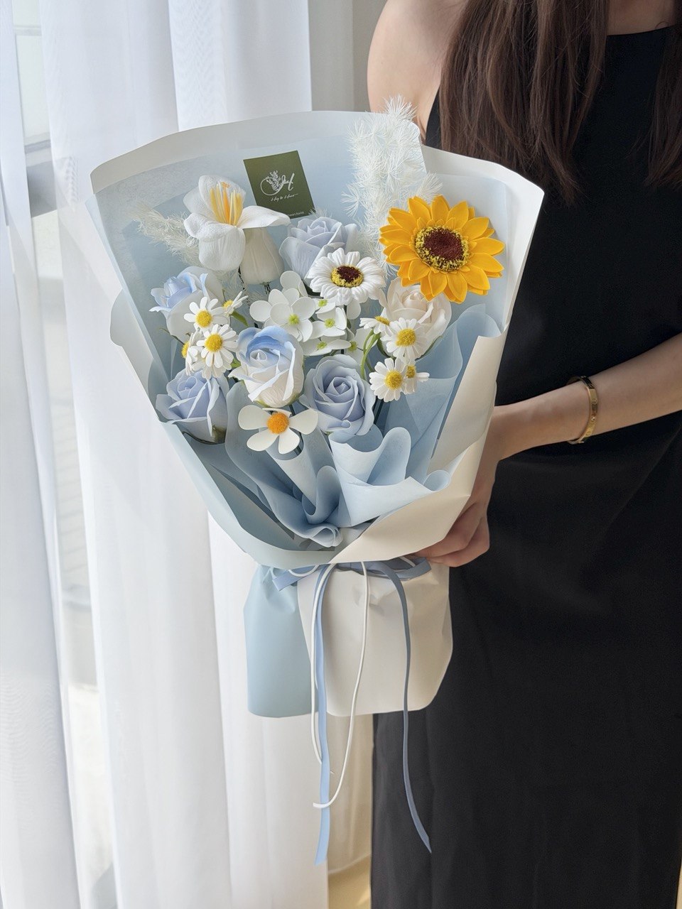 A girl is holding a soap flower with sunflower with blue wrapper perfect for graduation at university at Subang Jaya, Bukit Jalil.