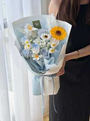 A girl is holding a soap flower with sunflower with blue wrapper perfect for graduation at university at Subang Jaya, Bukit Jalil.