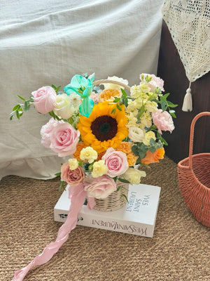 Bright sunflower recovery flower basket featuring pastel roses, carnations, and fresh seasonal flowers for get well soon wishes.