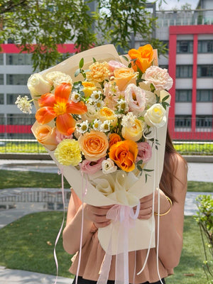 Premium orange tulip flower arrangement with white roses and pastel flowers for Mother's Day, anniversaries, and special occasions.
