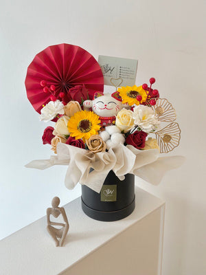 A black box with flowers and a red fan, showcasing a lucky cat, ideal for congratulating a friend's new business.