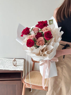 Bouquet of red and cappuccino roses held by a person in a neutral setting perfect for Valentine 2026 flower gift.