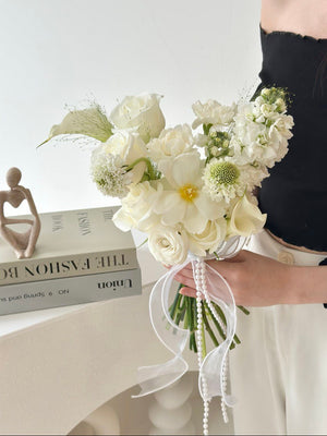 A bride proudly displays a bouquet of white Calla Lilies, adding a touch of elegance to her ROM wedding day.