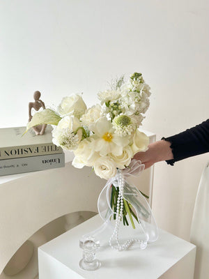 A bride holding a bouquet of white Calla Lilies, symbolizing elegance and joy for her ROM wedding ceremony.