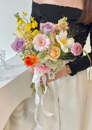 A bride holding a vibrant bouquet of ROM flowers on her wedding day, enhancing the festive atmosphere of the celebration.