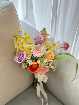 A bride joyfully holds a colorful bouquet of ROM flowers, adding beauty to her wedding day and the surrounding environment.