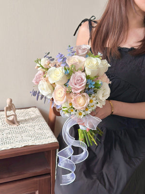 Elegant pastel rose wedding bouquet with white and menta roses, hana white and oxypetalum blue, tied with a flowing ribbon.
