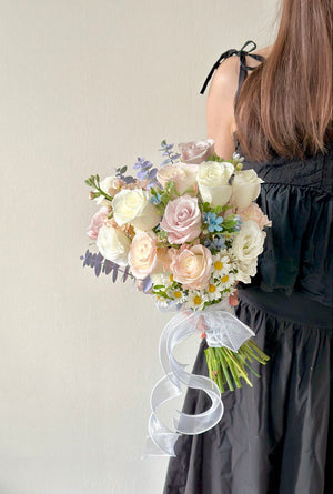 Romantic hand-tied bridal bouquet featuring menta rose, white rose, oxypetalum blue, eustoma and hana white with delicate filler flowers for weddings.