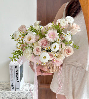Person holding a bouquet of flowers in a woven basket in front of a mirror, suitable for get well soon flower basket.