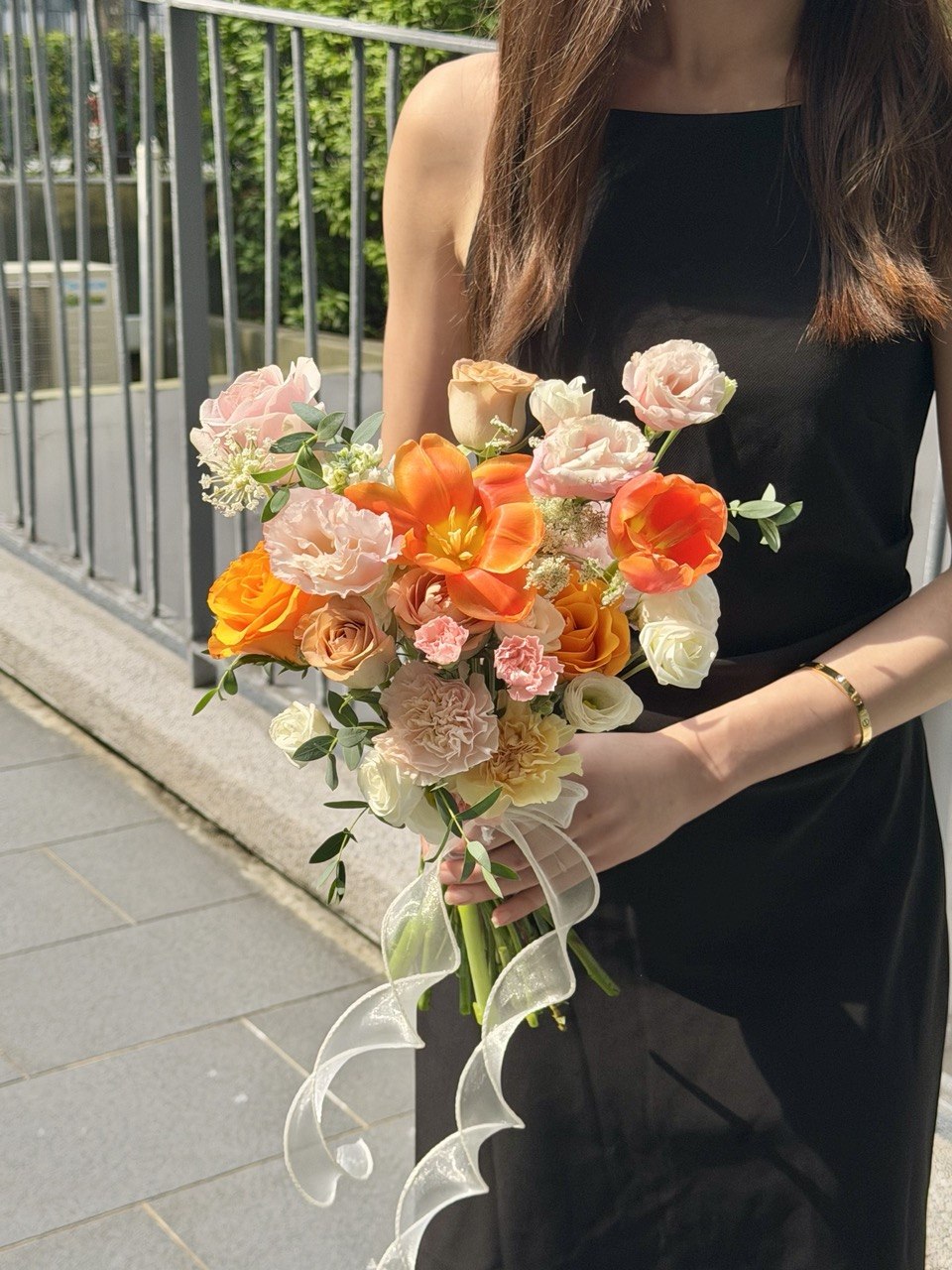 Premium orange tulip bridal bouquet featuring pink roses, soft pink flowers and fresh greenery for ROM and wedding ceremony.