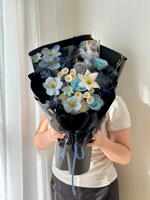 Elegant black wrapped soap flower bouquet featuring blue roses, white lily, tulips, and delicate white daisies with same day flower delivery in Kuala Lumpur.