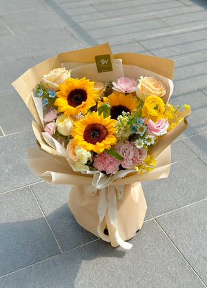 A sunflower mixed roses bouquet is placing at a black flooring with a glaze of sunlight at Subang Jaya