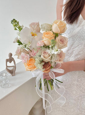 A woman in a white wedding dress holding a bouquet of Quicksand Rose at her wedding day at Kuala Lumpur