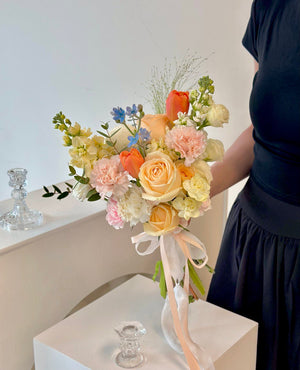 A woman wearing a black wedding dress holds a bright bouquet of flowers, symbolizing joy on her wedding day.