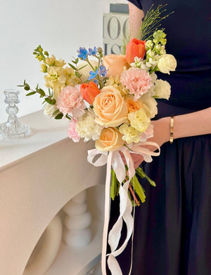 A woman in a black wedding dress holds a colorful bouquet of flowers, celebrating her wedding day.