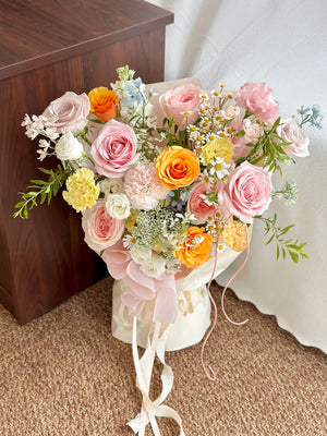 Woman holding a large, vibrant bouquet with a mix of roses, carnations, daisies, and lush greenery.