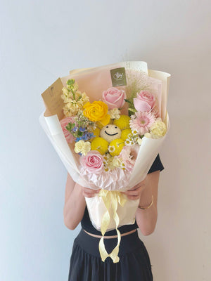A girl in a black dress joyfully holds a mixed flower bouquet mix with smiley ping pong, celebrating her graduation.