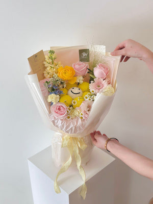 A girl is showing her hand at a bouquet of flowers, celebrating her achievement.