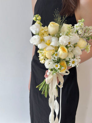 Delicate butter yellow roses combined with white florals and daisy-like blooms – a romantic bouquet perfect for modern brides.